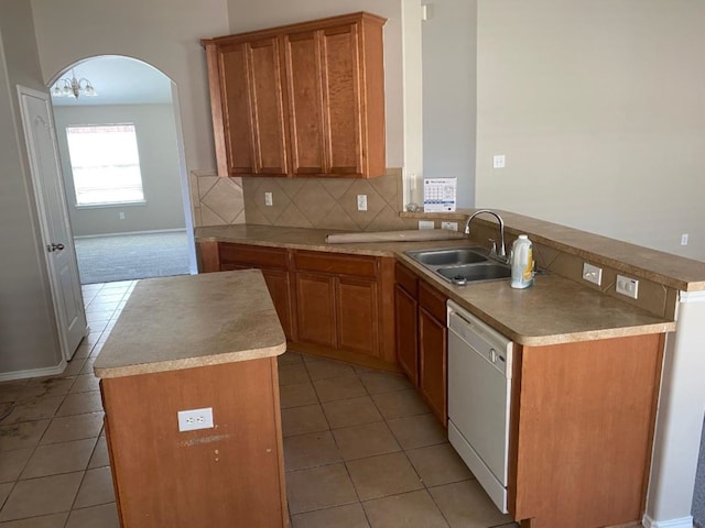 kitchen with sink, decorative backsplash, dishwasher, and a kitchen island