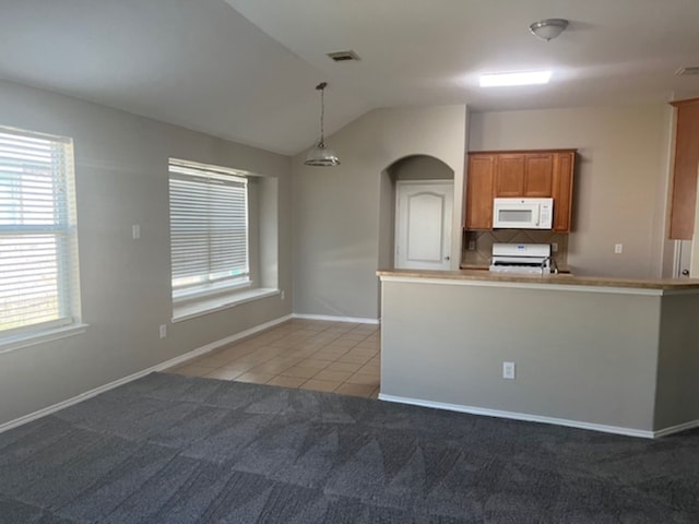 kitchen with lofted ceiling, decorative backsplash, light carpet, decorative light fixtures, and range