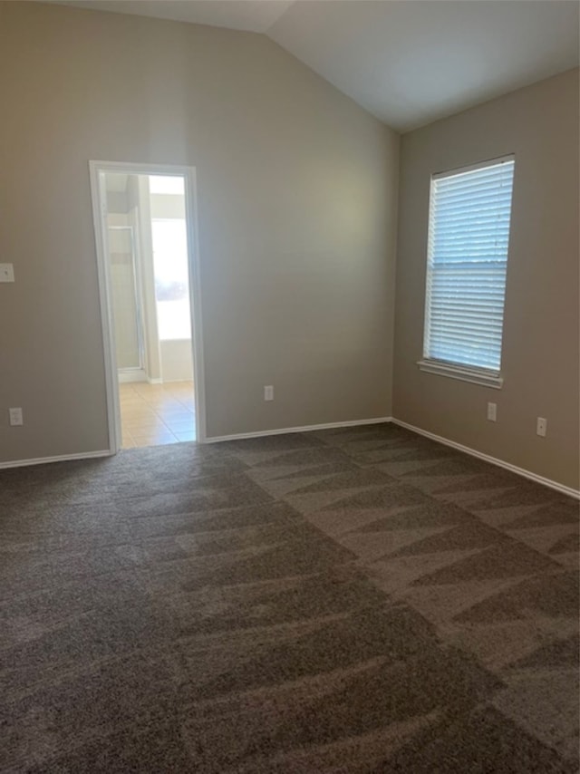 carpeted spare room with lofted ceiling and plenty of natural light