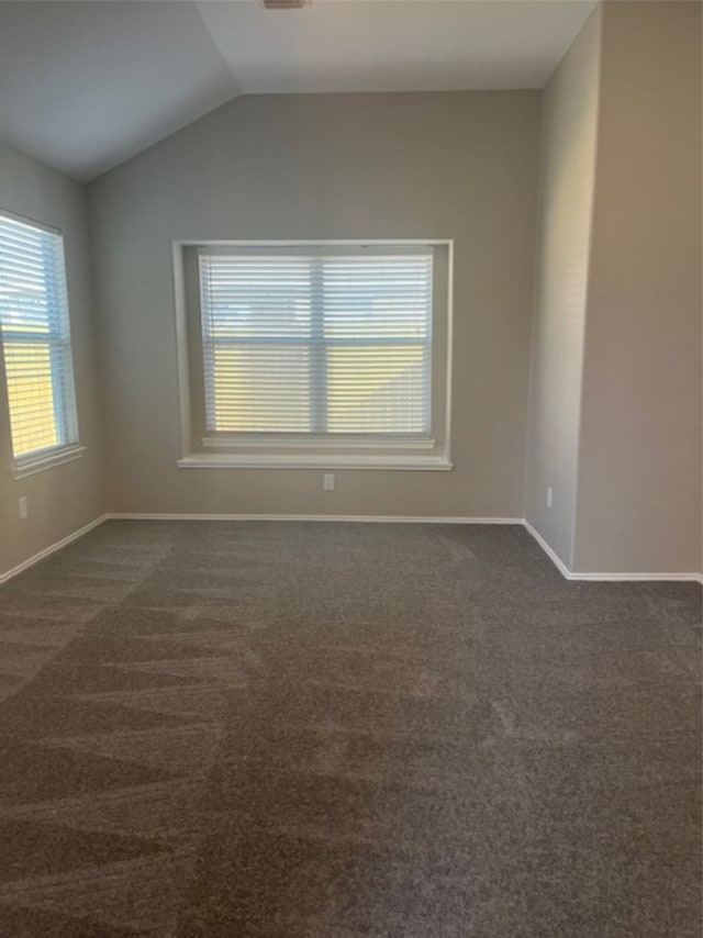 carpeted empty room with vaulted ceiling