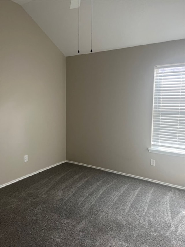 carpeted spare room featuring vaulted ceiling