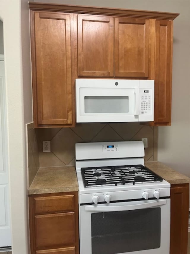 kitchen with white appliances and tasteful backsplash