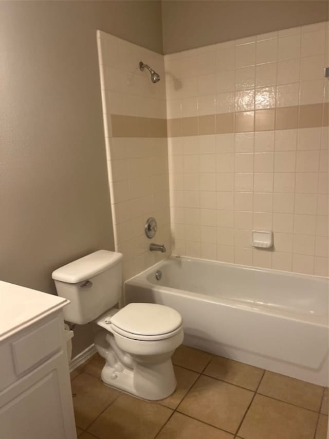 full bathroom featuring vanity, tiled shower / bath combo, toilet, and tile patterned floors