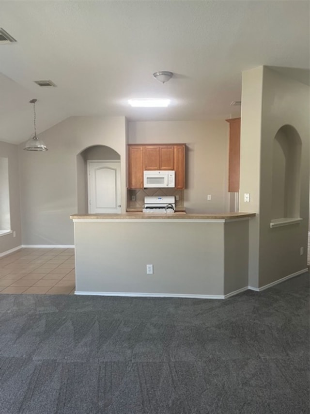 kitchen featuring range, carpet, decorative light fixtures, and kitchen peninsula