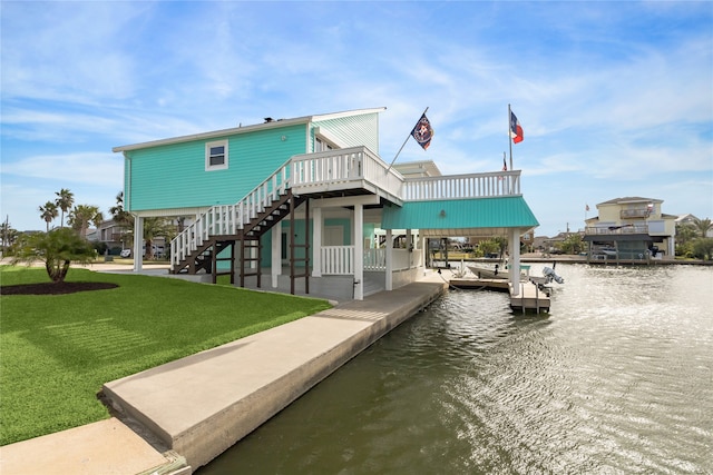 view of dock with a deck with water view and a lawn