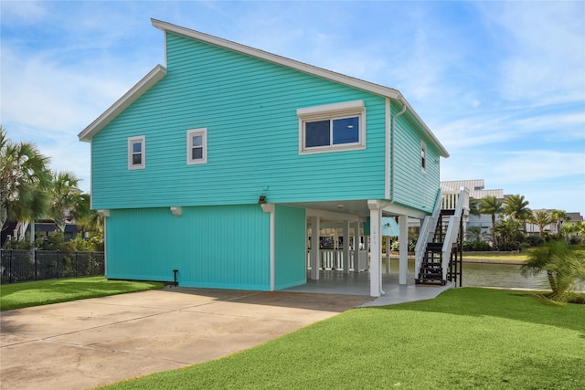 rear view of house with a lawn and a carport