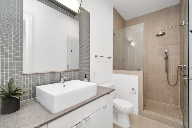 bathroom with vanity, toilet, tile walls, and a shower with shower door