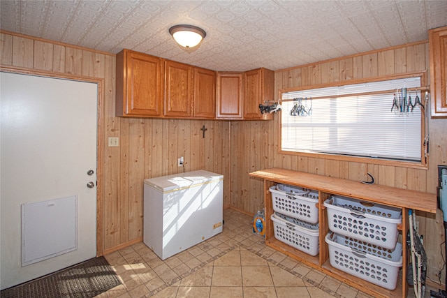 laundry room with cabinets, light tile patterned flooring, and wooden walls