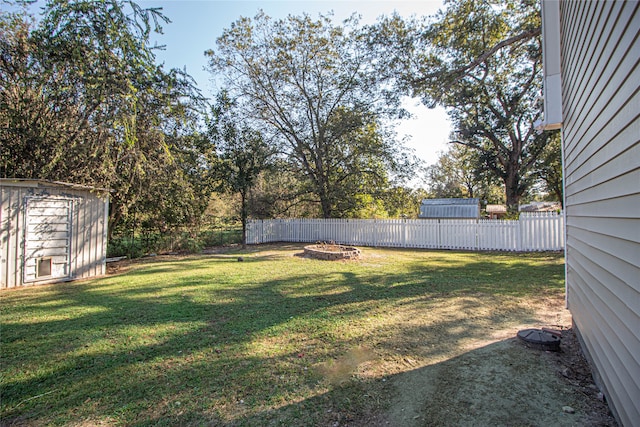 view of yard with an outdoor fire pit and a storage unit