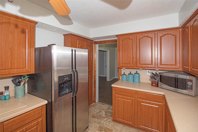 kitchen with ceiling fan, appliances with stainless steel finishes, and a textured ceiling