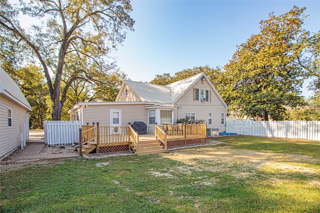 rear view of property featuring a yard and a wooden deck