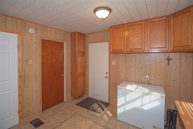 kitchen with light tile patterned flooring and wood walls