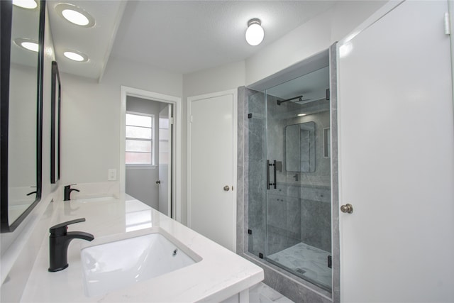 bathroom with vanity, a textured ceiling, and a shower with shower door