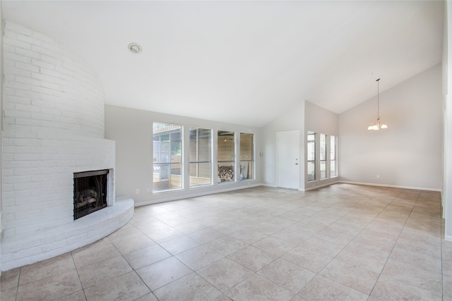 unfurnished living room with a chandelier, light tile patterned flooring, a brick fireplace, and high vaulted ceiling