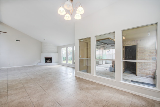 unfurnished living room with high vaulted ceiling, light tile patterned floors, a brick fireplace, and ceiling fan with notable chandelier