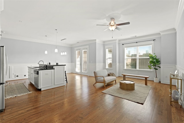 living room featuring ornamental molding, sink, wood-type flooring, and ceiling fan