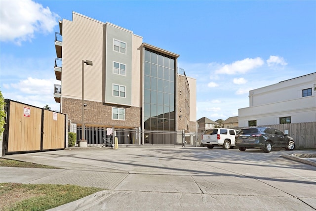 2802 Morrison St Unit 206, Houston, TX 77009 - view of building exterior featuring uncovered parking and fence