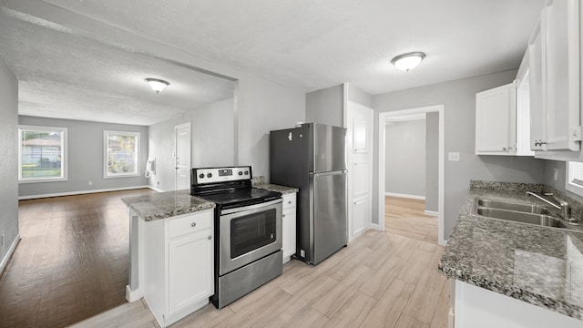 kitchen featuring stainless steel appliances, sink, light wood-type flooring, and white cabinets