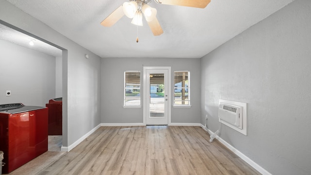 entryway with an AC wall unit, light hardwood / wood-style floors, and ceiling fan