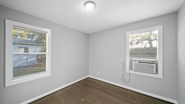 unfurnished room with cooling unit and dark hardwood / wood-style flooring