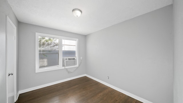 spare room with a textured ceiling, dark hardwood / wood-style flooring, and cooling unit