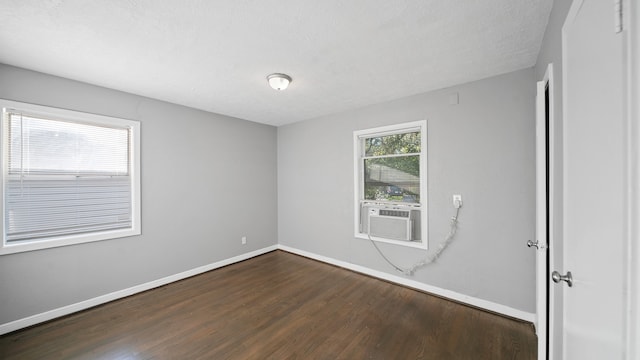 unfurnished room featuring cooling unit, a textured ceiling, and dark hardwood / wood-style floors