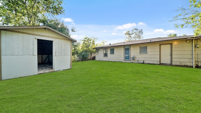 back of house featuring an outdoor structure and a yard