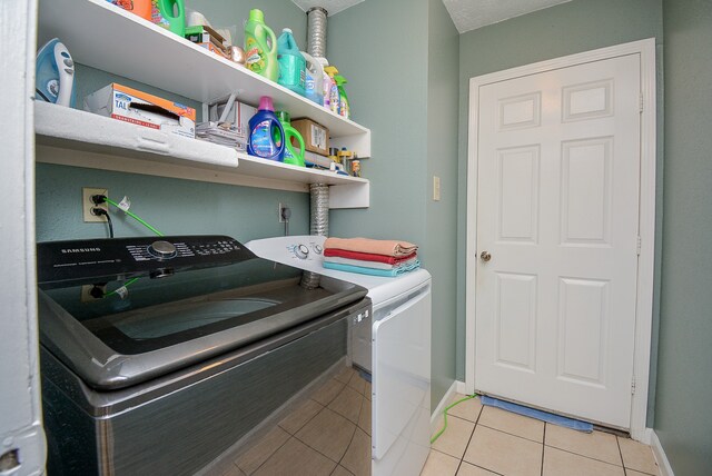 clothes washing area featuring light tile patterned floors and separate washer and dryer