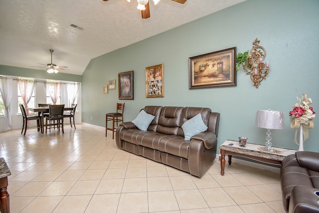 tiled living room featuring vaulted ceiling, a textured ceiling, and ceiling fan