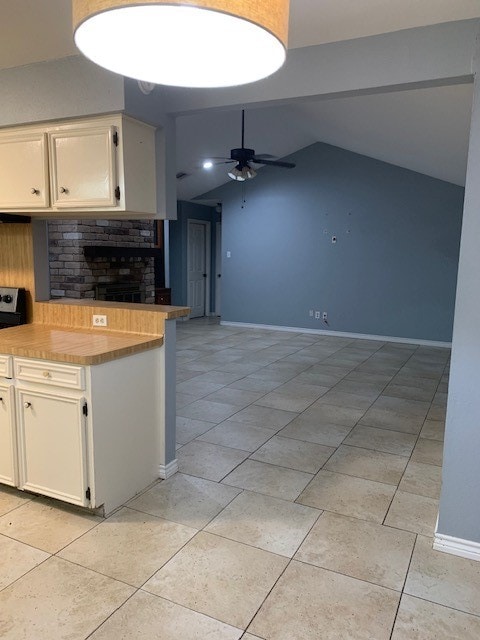 kitchen with white cabinetry, light tile patterned floors, vaulted ceiling, and ceiling fan