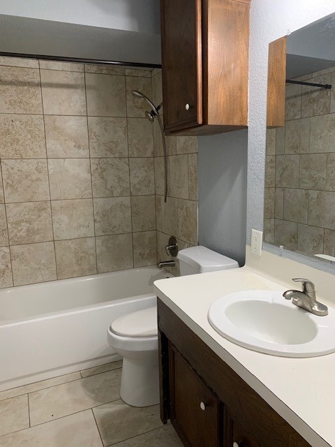 full bathroom featuring vanity, toilet, and tiled shower / bath