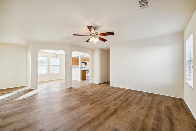 unfurnished living room with hardwood / wood-style flooring and ceiling fan with notable chandelier