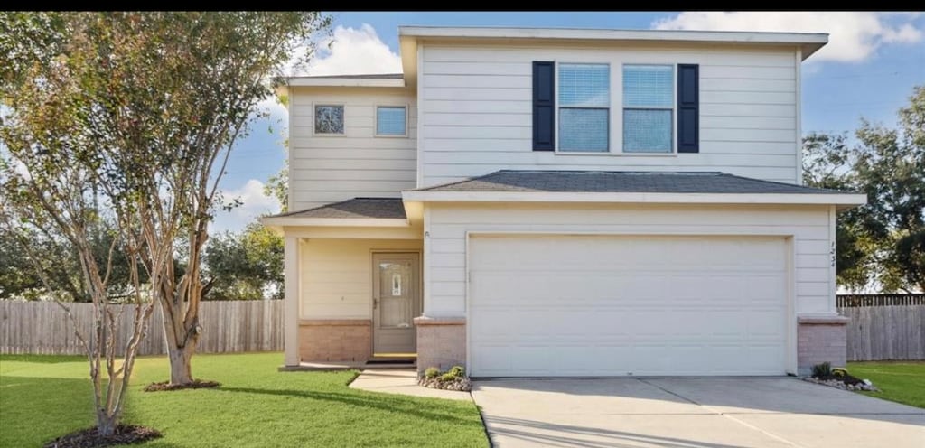 front facade featuring a garage and a front lawn