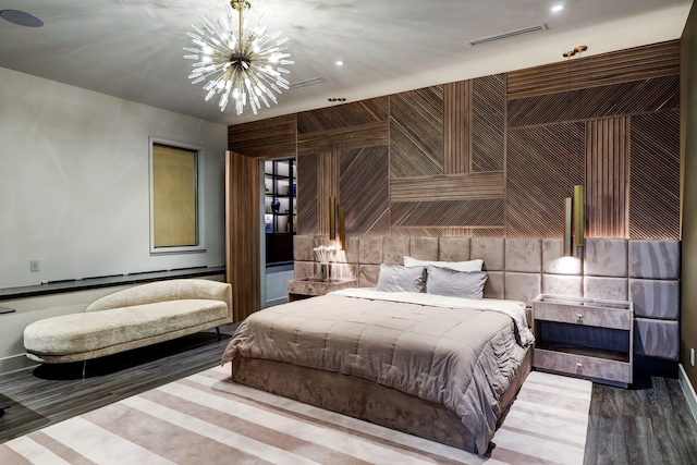 bedroom featuring an inviting chandelier and wood-type flooring