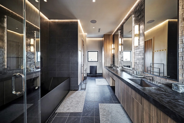 bathroom featuring vanity, a tub to relax in, and tile walls