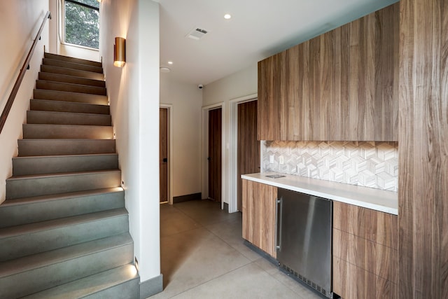 kitchen with backsplash and stainless steel fridge