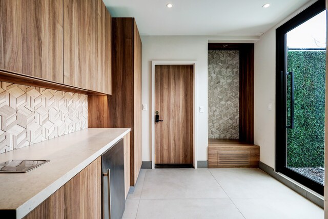 kitchen featuring light tile patterned flooring, beverage cooler, and tasteful backsplash