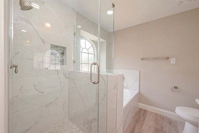 bathroom with toilet, hardwood / wood-style flooring, and shower with separate bathtub