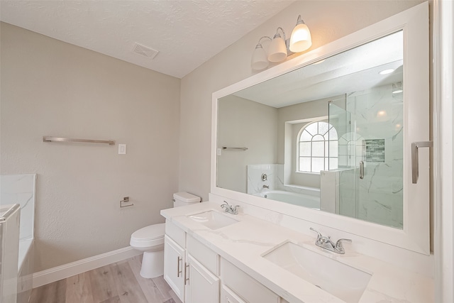 full bathroom featuring wood-type flooring, plus walk in shower, a textured ceiling, toilet, and vanity