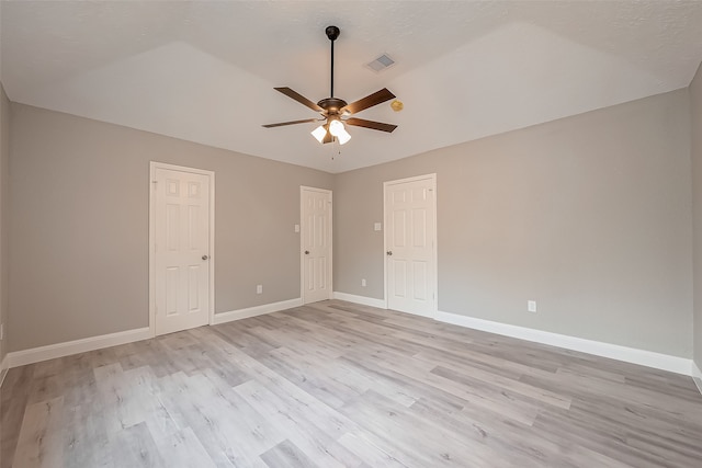 unfurnished room with ceiling fan, vaulted ceiling, and light wood-type flooring