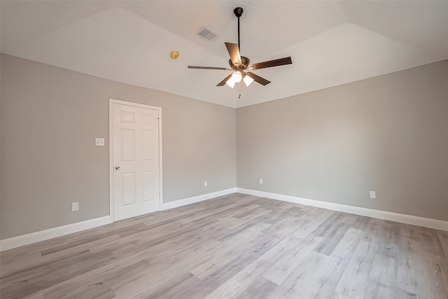 spare room featuring ceiling fan, lofted ceiling, and light wood-type flooring