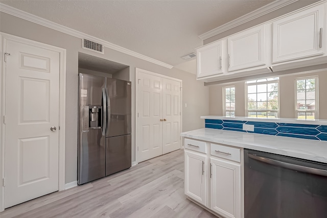 kitchen with crown molding, white cabinets, stainless steel appliances, and light wood-type flooring