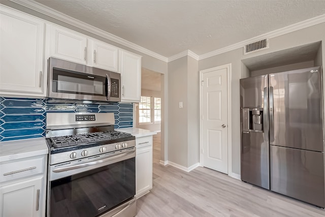 kitchen with light hardwood / wood-style flooring, backsplash, light stone countertops, white cabinets, and appliances with stainless steel finishes