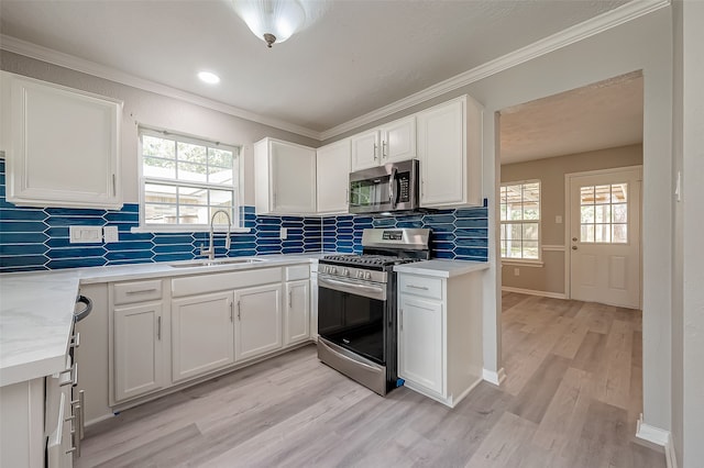 kitchen with plenty of natural light, appliances with stainless steel finishes, sink, and light wood-type flooring