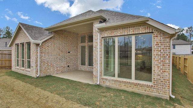 back of house with a patio and a lawn