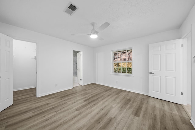 spare room with light hardwood / wood-style flooring, a textured ceiling, and ceiling fan