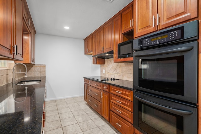 kitchen featuring sink, decorative backsplash, dark stone countertops, and black appliances