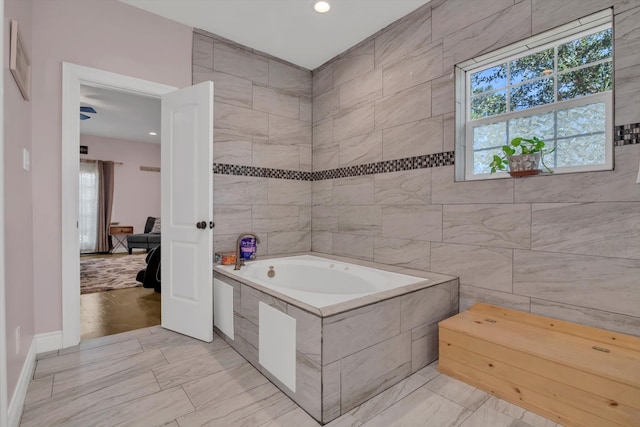 bathroom with a bathing tub and tile walls