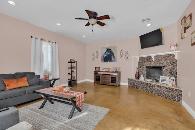 living room with concrete flooring, a fireplace, and ceiling fan