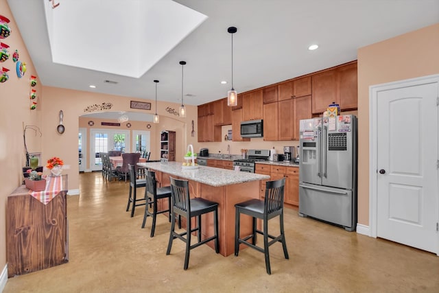 kitchen featuring a center island with sink, light stone counters, a kitchen breakfast bar, pendant lighting, and stainless steel appliances